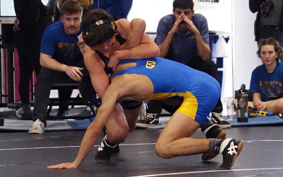 Yokota 107-pounder Ethan Romney takes a shot against Christian Academy Japan’s Tai Leaf during Saturday’s Zama Invitational. Romney won the weight class.