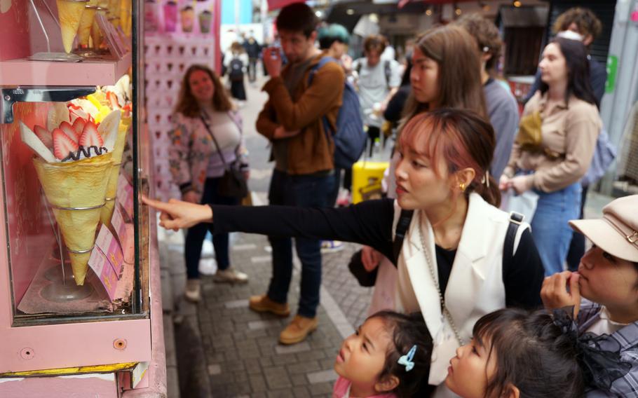 People check out crepes on Takeshita Street in Tokyo's Harajuku district, Monday, May 8, 2023. 