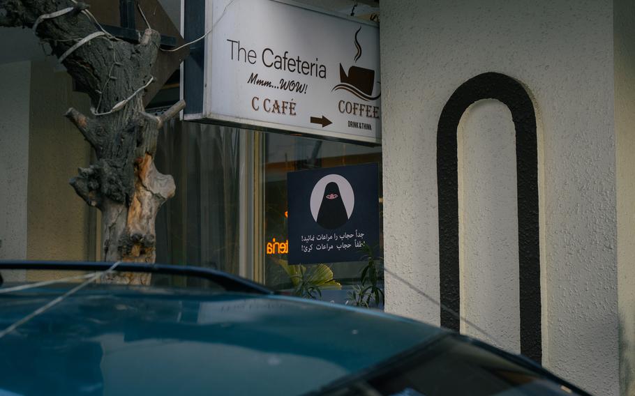 A Taliban government sign at the entrance to a coffee shop reminds women to observe dress code and hijab policies.