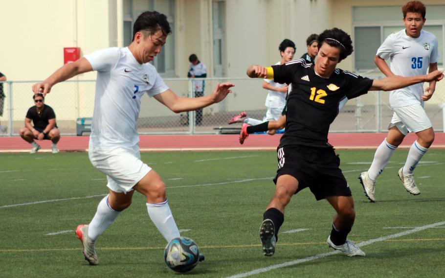 CAJ's Takatoshi Kanemura and Kadena's Will Weatherill scrap for the ball.