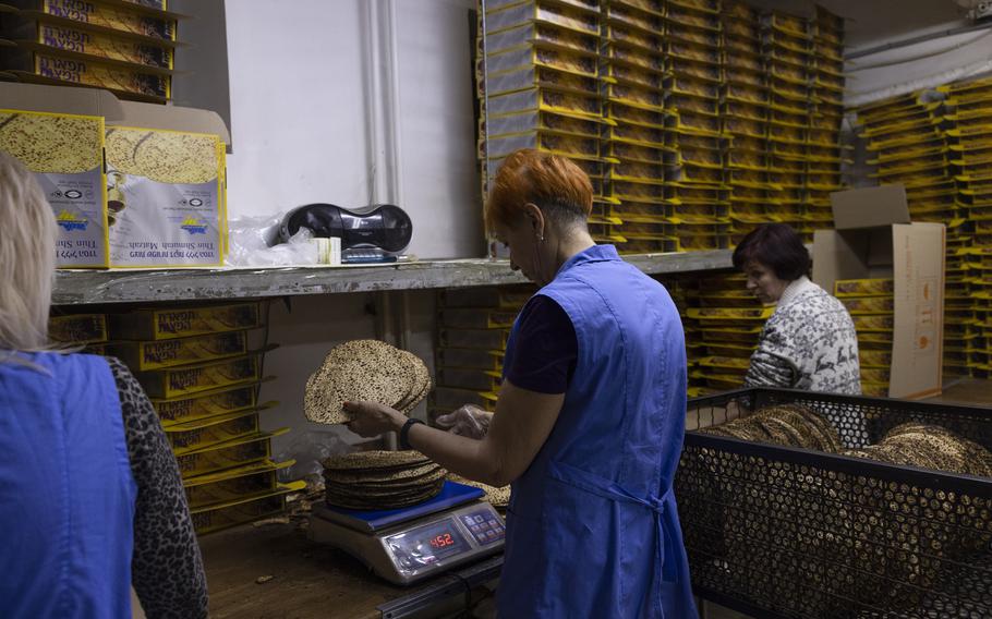 Workers at the Tiferet Matzah factory weigh and packaging freshly baked Kosher matzoh in Dnipro, Ukraine, on Dec. 14, 2022. 