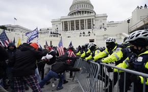 FILE - Rioters supporting President Donald Trump try to break through a police barrier at the Capitol in Washington, on Jan. 6, 2021.(AP Photo/Julio Cortez, File)
