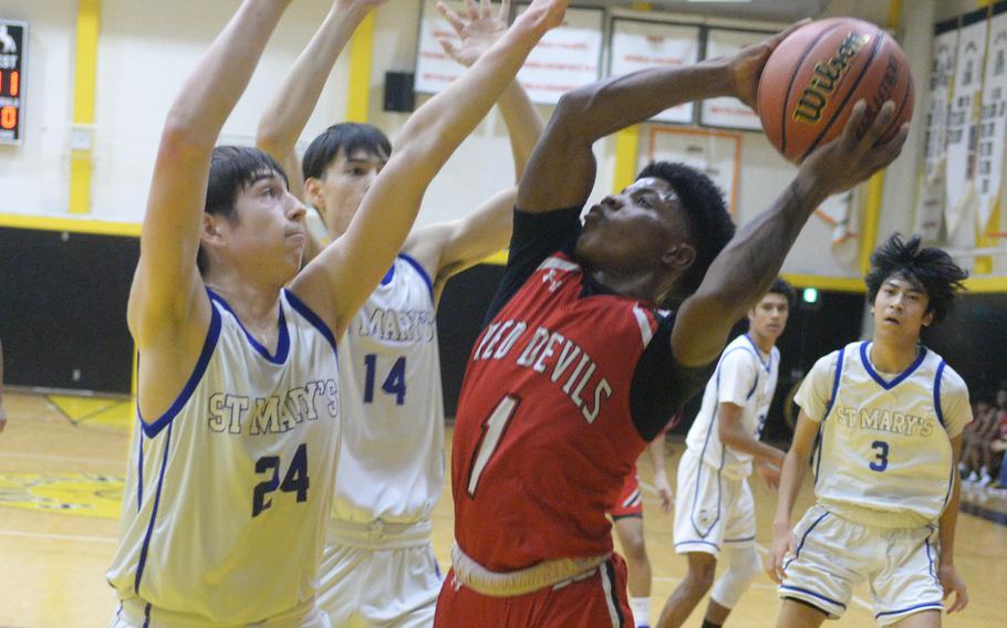 Kinnick's Xavier Wright tries to shoot against St. Mary's Zach Bingham and Vincent Willis.