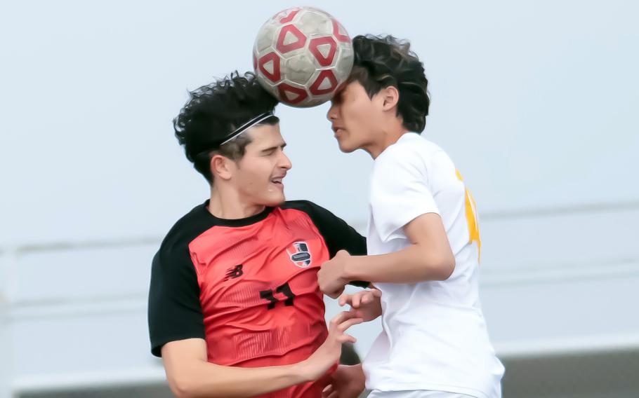 Esteban Diaz and Alexander Brodus try to head the ball.
