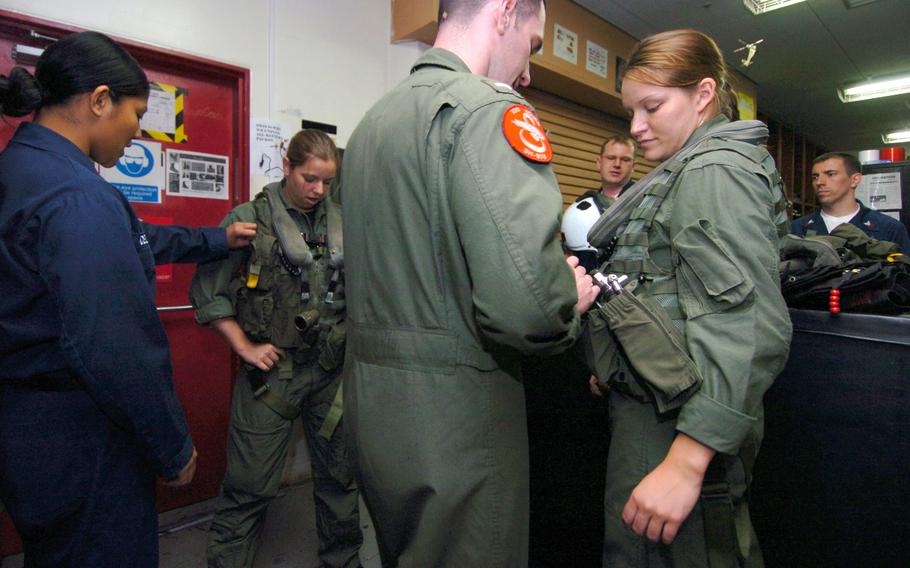 A sailor tries on their flight gear