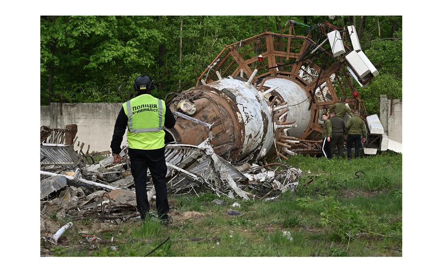A Ukrainian police investigator examines debris at the Kharkiv Television Tower on the outskirts of Kharkiv on April 22, 2024. 