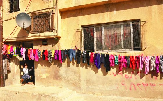 A young Syrian girl stands ﻿at the door of her home in the Baqa’a refugee camp near Amman, Jordan.﻿ Palestinians helped move her family into the camp that is home to a majority of Palestinians.

Read Cid Standifer's 2013 article on the Palestinian and Syrian refugee crises here. https://www.stripes.com/news/other-refugees-worry-over-aid-as-syrian-plight-takes-spotlight-1.245127

META TAGS: refugee camp; dispaced; Palestine; Jordan; Syria; humanitarian aid; humanitarian crisis