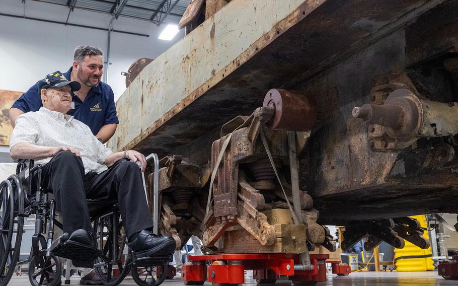 A man shows a Marine veteran a tank.