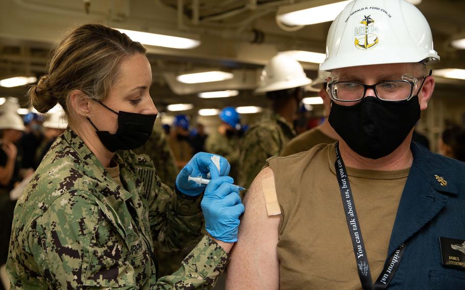 Lt. Cmdr. Susan Murphy of Modesto, Calif., administers a flu shot to James Meggison aboard the USS Gerald R. Ford.