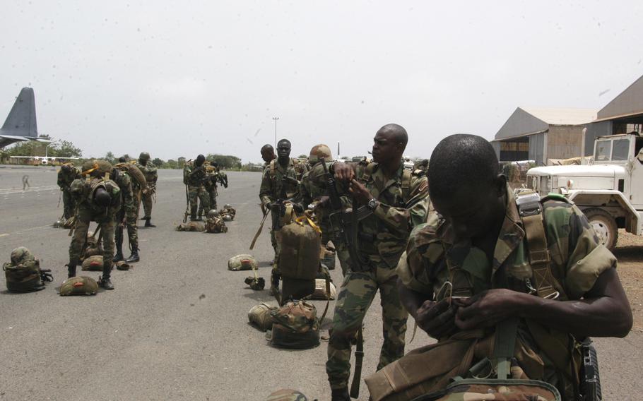 Senegalese paratroops and commandos ready their gear before they join U.S. Army Special Forces soldiers on a combined skydiving exercise. 