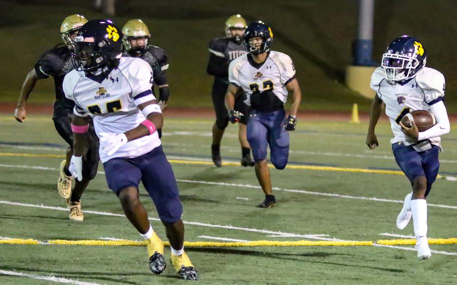 Panthers QB Aaron Johnson gets an escort around left end as he begins a 60-yard touchdown run against Tiyan.