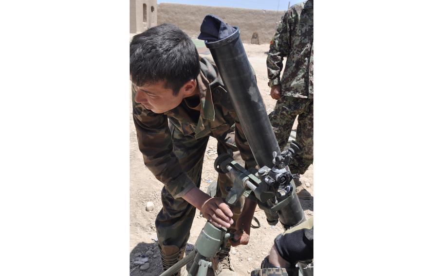 An Afghan National Army soldier works with a mortar launcher after Americans offer some additional training on aiming. The ANA fired mortars from Patrol Base Cuba, which is serving as a headquarters for the fight against the Taliban in Sangin District.