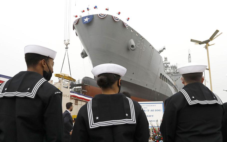 Sailors stand pierside near the USNS Harvey Milk set to be christened at General Dynamics NASSCO.