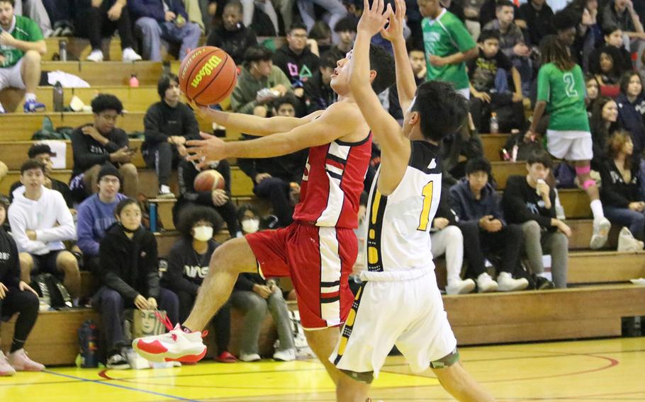 Okinawa Christian's Jackson Skarin tries to drive past Kadena's Jaden Patsel during Monday's Far East Boys Division I Tournament pool-play game, won by the Panthers 48-37.