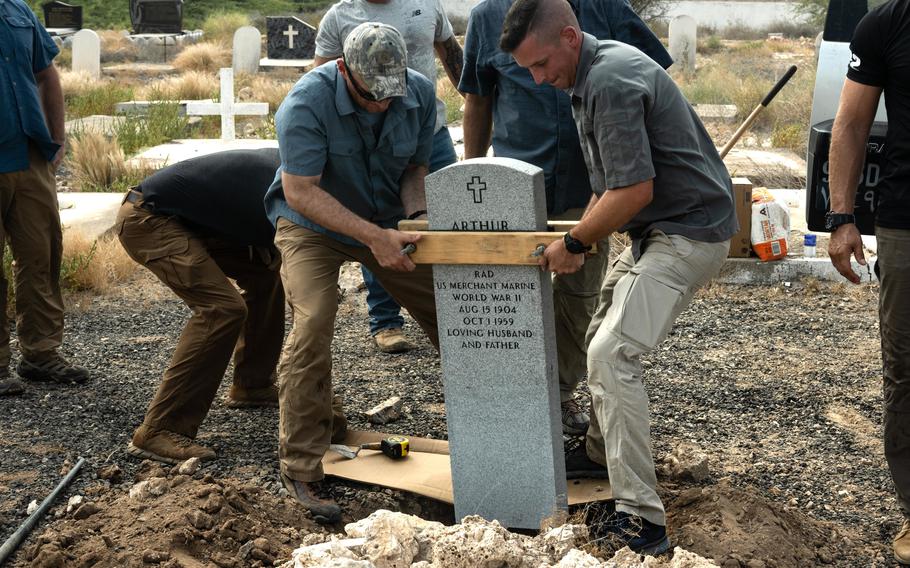 Soldiers assigned to the 377th Engineer Vertical Construction Company place a new headstone for World War II veteran Arthur Lewis, at the New European Cemetery in Djibouti city, Djibouti, Oct. 5, 2021. 
