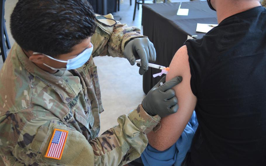 Pvt. Bruno Manosalvas, a medic with the 215th Brigade Support Battalion, administers a vaccine shot Wednesday at a pop-up clinic at Fort Hood, Texas. 