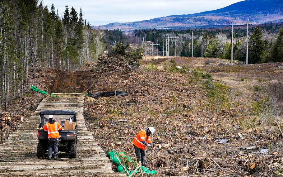 Workers for Northern Clearing pound stakes to mark land on an existing Central Maine Power power line corridor, that has been recently widened to make way for new utility poles, on April 26, 2021, near Bingham, Maine. 