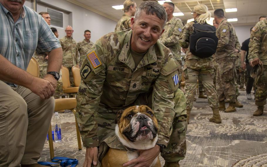 A soldier embraces Rocky the Bulldog, the live mascot for the division.