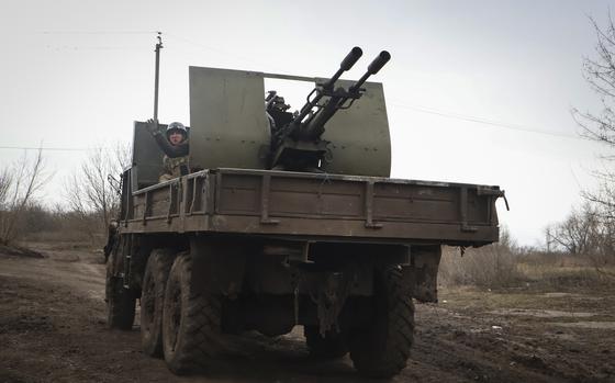 A Ukrainian soldier waves on the road near Bakhmut, Donetsk region, Ukraine, Saturday, March 18, 2023.