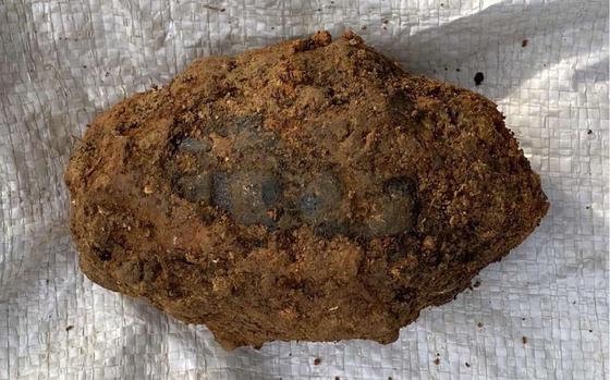This grenade, found caked in dirt at a former U.S. military training site in northern Okinawa, has gone missing, according to the Japanese military. 