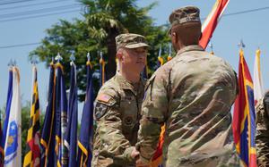 Brig. Gen. James Dooghan reaches for the U.S. Army Japan guidon as Gen. Ronald Clark hands it over.