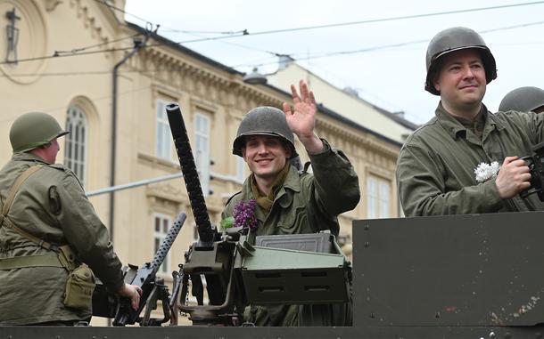 A historical reenactor in period American military dress waves to the crowd during Liberation Festival Pilsen's parade of military vehicles, called the Convoy of Liberty, on Sunday, May 5, 2024.
