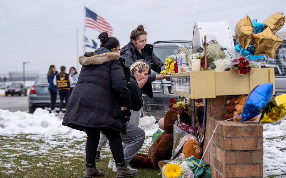 A group gets emotional after leaving flowers at a memorial at an entrance to Oxford High School on Dec. 1, 2021, following an active shooter situation at Oxford High School that left four students dead and multiple others with injuries. 