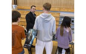 Kids line up to ask questions of Chief Navy Counselor Christopher Stevens, 40, from Navy Recruiting Far East, Yokosuka, Japan, during a career day fair at Yokota Air Base's middle school in Yokota, Japan, on May 5, 2022. (Juan King/Stars and Stripes)