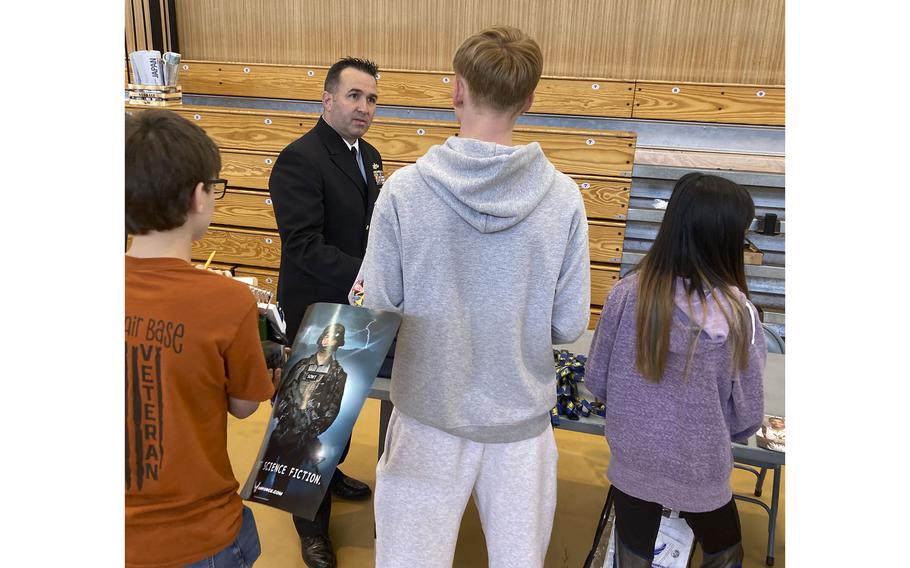 Students line up to speak with Chief Christopher Stevens, a Navy counselor, during Career Day at Yokota Air Base, Japan, in May 2022.