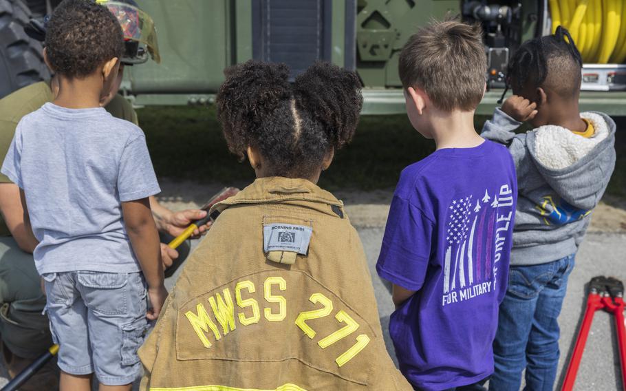 U.S. Marine Corps Cpl. Gabriel Soto, left, a native of California and an expeditionary firefighting and rescue specialist with Marine Wing Support Squadron (MWSS) 271, talks with students about crash-fire rescue tools during a career fair at Oaks Road Academy in New Bern, N.C., Friday, April 19, 2024. 