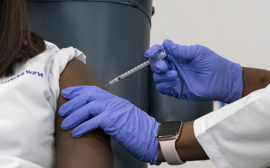 Sandra Lindsay, left, a nurse at Long Island Jewish Medical Center, is inoculated with the Pfizer-BioNTech COVID-19 vaccine by Dr. Michelle Chester, Monday, Dec. 14, 2020, in the Queens borough of New York. (AP Photo/Mark Lennihan, Pool)