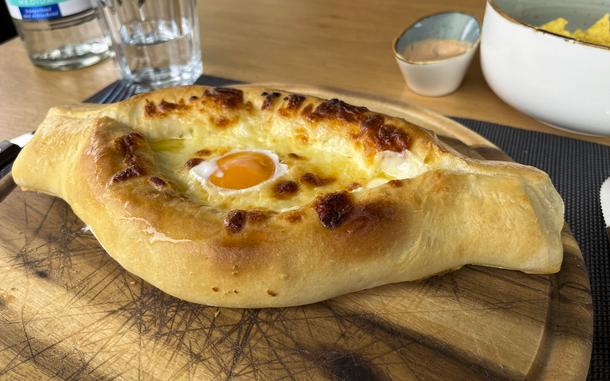 The Adjarian khachapuri at Kinto is one variation of Georgia's national dish. The leavened bread dough is formed into a boat, filled with cheese and butter, and topped with an egg yolk, which cooks when mixed with the cheese. 