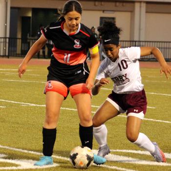 E.J. King's Maliwan Schinker and Matthew C. Perry's Ivanelis Nieves try to play the ball during Friday's DODEA-Japan soccer match. The teams tied 1-1.