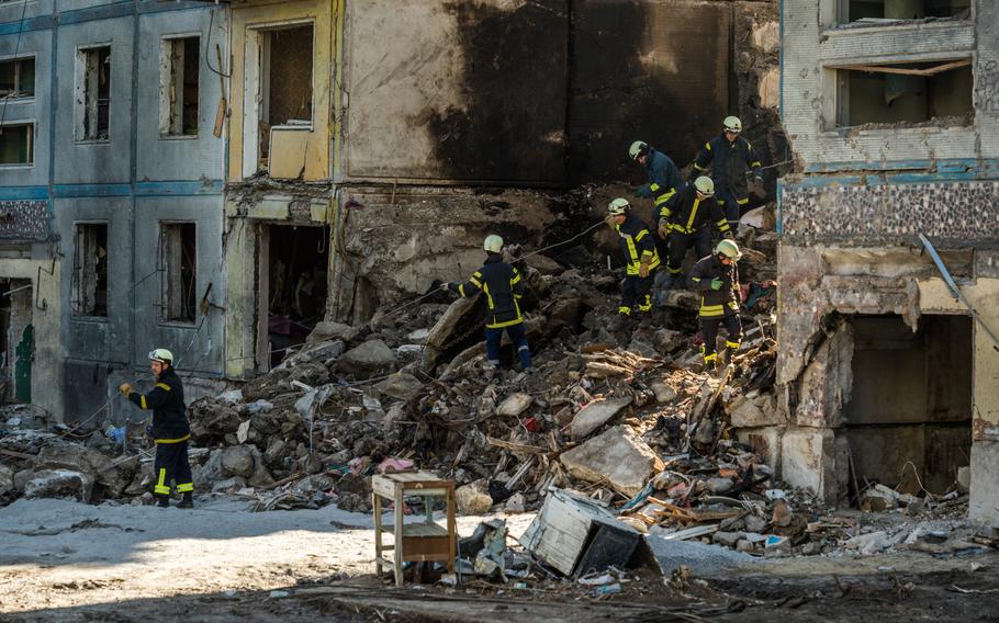 Firefighters clear the rubble of a destroyed apartment building in Zaporizhzhia.
