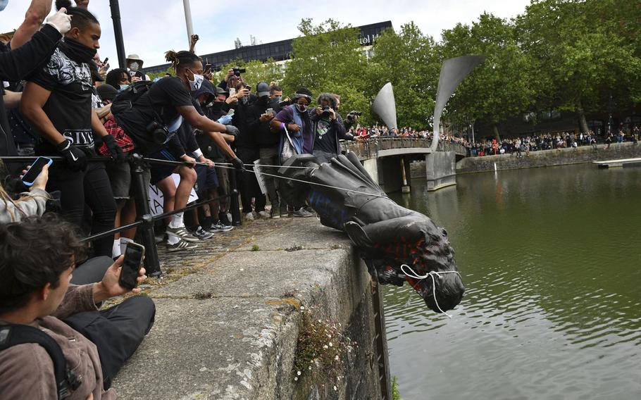 Protesters throw a statue of Edward Colston into the Bristol harbour during a Black Lives Matter protest rally, in Bristol, England, on June 7, 2020.