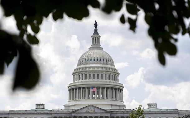 The U.S. Capitol dome behind tree leaves 