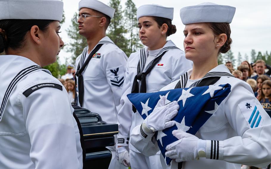 Builder Seaman Bailey Albert, of Navy Reserve Center Sacramento funeral honor detail, prepares the flag for transfer at retired Lt. Cmdr. Lou Conter’s memorial service.