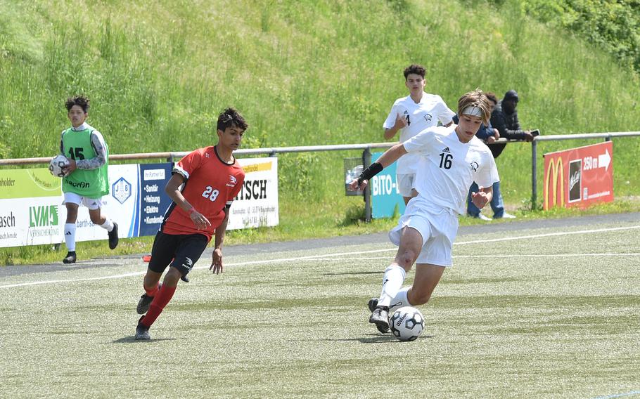 Vicenza defender Andrew McGovern beats American Overseas Schools of Rome winger Rayan Rainieri during a Division II semifinal at the DODEA European soccer championships on May 17, 2023, at VfR Baumholder's stadium in Baumholder, Germany.