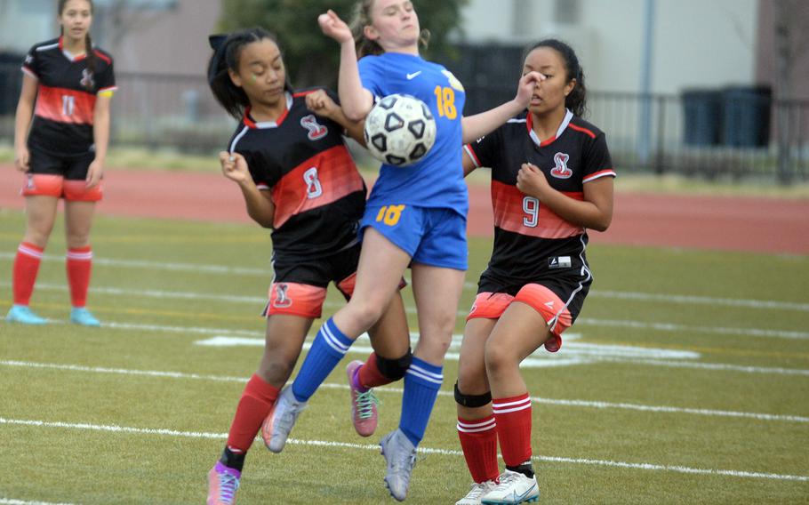 E.J. King's Miu Best and Katelyn Mapa sandwich Yokota's Hailey Riddels trying to settle the ball during Friday's DODEA-Japan girls soccer match. The Cobras won 2-1.