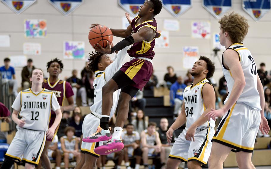 Vilseck's Kendall Terrell goes up for a shot while Stuttgart's Tyler Jackson defends during round-robin action of the Division I DODEA European Basketball Championships on Friday at Ramstein High School on Ramstein Air Base, Germany. Following the play are, from left, Stuttgart's Chris Hess, Trenton Jackson and Jacob Schudel.