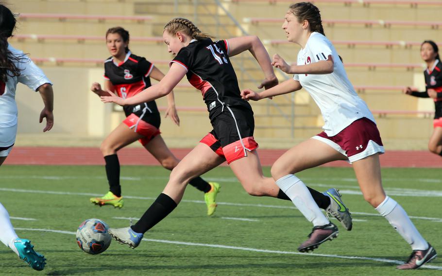 E.J. King's Madylyn O'Neill drives the ball upfield past Matthew C. Perry's McKenzie Mitchell during Saturday's Trojan War Cup match. The Cobras won 2-1.