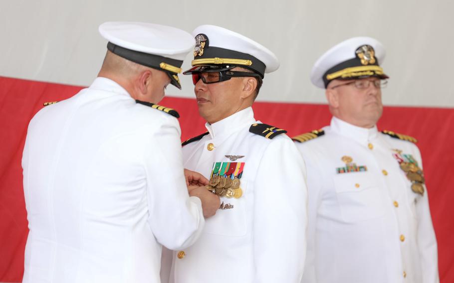 Cmdr. Manny Sanchez, commander of the Center for Naval Aviation Technical Training Unit Lemoore, pins the Meritorious Service Medal onto Chief Warrant Officer 4 Jules Amores during Amores’ retirement ceremony Friday, March 25, 2022, at Naval Air Station Lemoore, Calif., as Capt. Steve Leehe, commander of Fleet Readiness Center Southwest, stands behind.