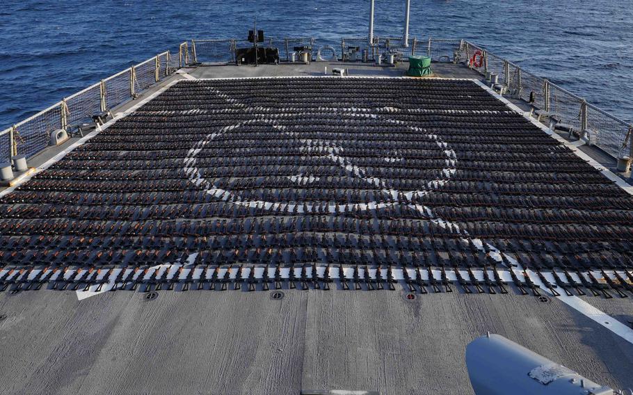 Thousands of AK-47 assault rifles sit on the flight deck of the destroyer USS The Sullivans during an inventory process in the Gulf of Oman, Jan. 7, 2023. U.S. naval forces seized 2,116 AK-47 assault rifles from a fishing vessel moving along a route from Iran to Yemen. 