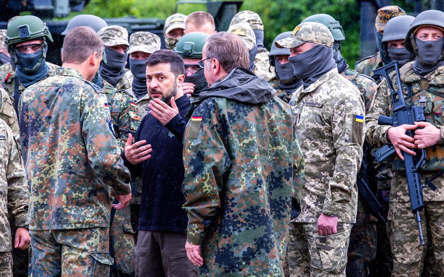 President Volodymyr Zelenskyy speaks to a group of soldiers around him.