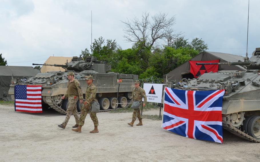 British and American soldiers walk out of a command post established for a multination training exercise Thursday, April 20, 2023, at Fort Hood, Texas.