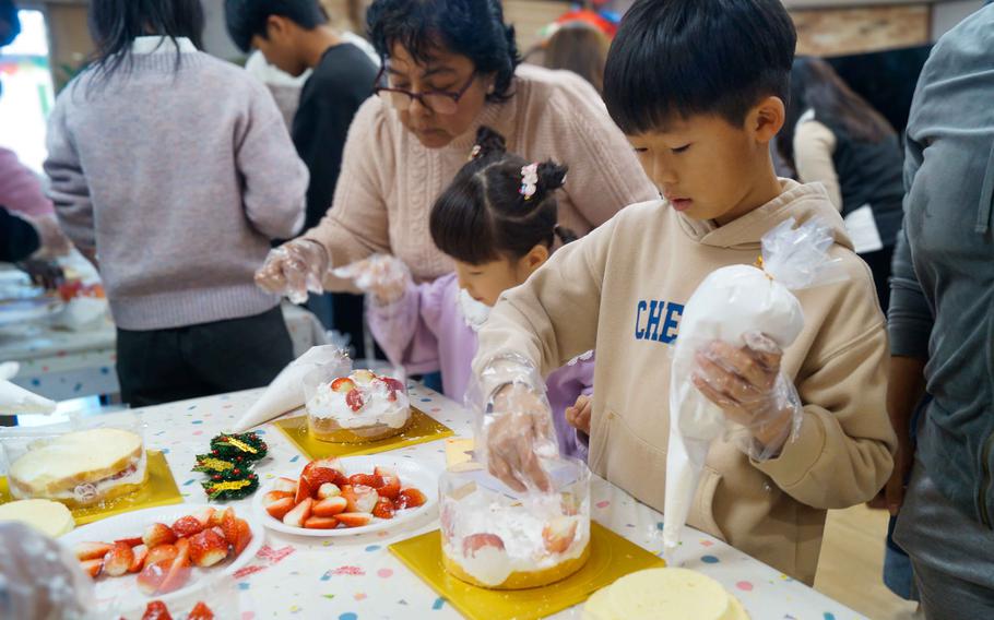 A child makes a cake with volunteers from Camp Humphreys at Ikseonwon Orphanage in Cheonan, South Korea, on Dec. 23, 2023. 