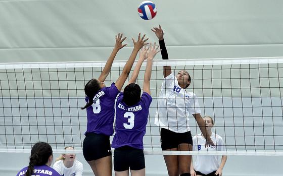 Aviano's Sophia Fisher, right, playing for Team White, hits the ball at the net while Team Purple's, from left, A'Lydia McNeal of Lakenheath and Lynnea Diaz Gonzalez of Black Forest Academy go for the block during a DODEA Europe all-star volleyball match Saturday at Ramstein High School on Ramstein Air Base, Germany.