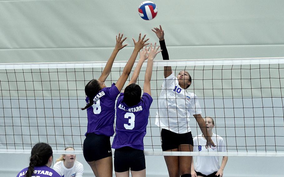 Aviano’s Sophia Fisher, right, playing for Team White, hits the ball at the net while Team Purple’s A’Lydia McNeal of Lakenheath, left, and Lynnea Diaz Gonzalez of Black Forest Academy go for the block during a DODEA-Europe all-star volleyball match Saturday at Ramstein High School on Ramstein Air Base, Germany.