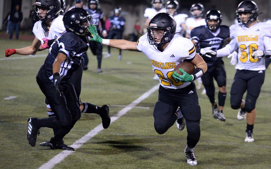 American School In Japan's Noa Grasse stiff-arms Zama defender Ayden Helton as he traverses left end.