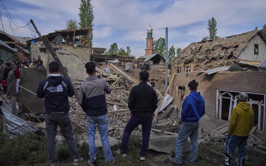 Kashmiri villagers look at several damaged homes from a deadly attack.